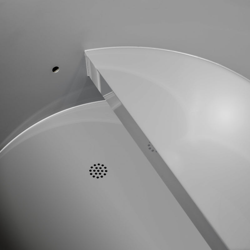 Close-up of a cold plunge drain in a white shower enclosure with a gray background