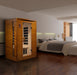 Infrared sauna in a modern bedroom setting with a bed and lamp.