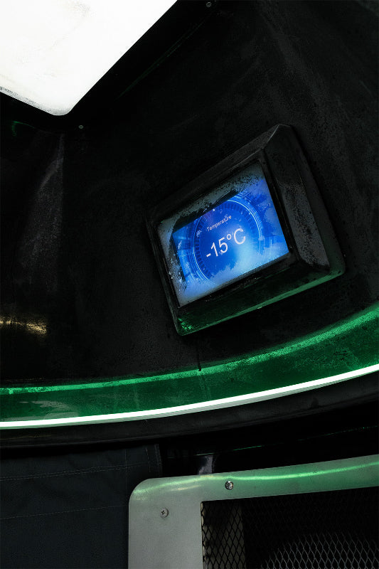 blue digital display inside cryotherapy chamber with green lights and black background