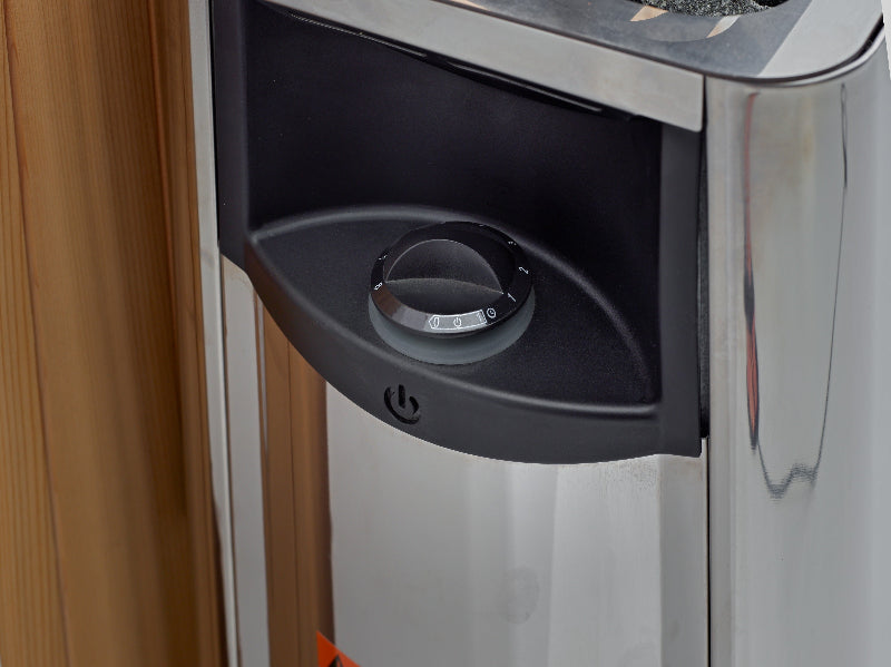 Sauna silver heating unit with dial for adjusting with light brown wood background