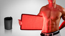 Man holding a red light therapy panel with a gray background
