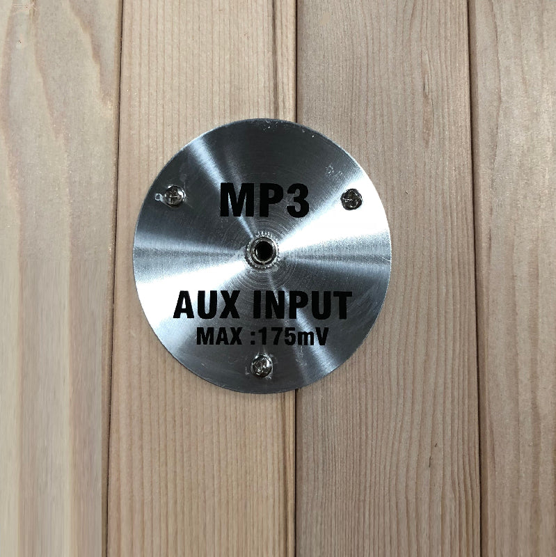 Metallic round label with 'MP3 AUX INPUT MAX: 175mV' text on a wooden surface