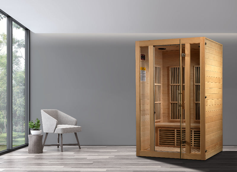 Wooden sauna in a modern room with a gray wall and large windows.