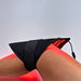 Black LED therapy device on a person's knee with red light emission.