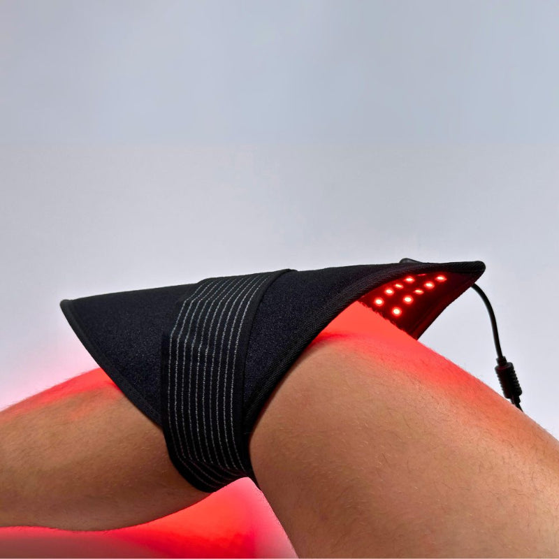 Black LED therapy device on a person's knee with red light emission.